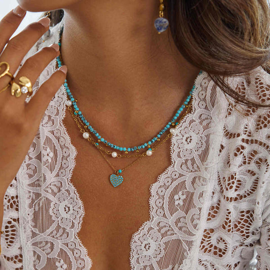 Turquoise pavé heart pendant necklace on delicate gold chain, worn layered with beaded necklaces