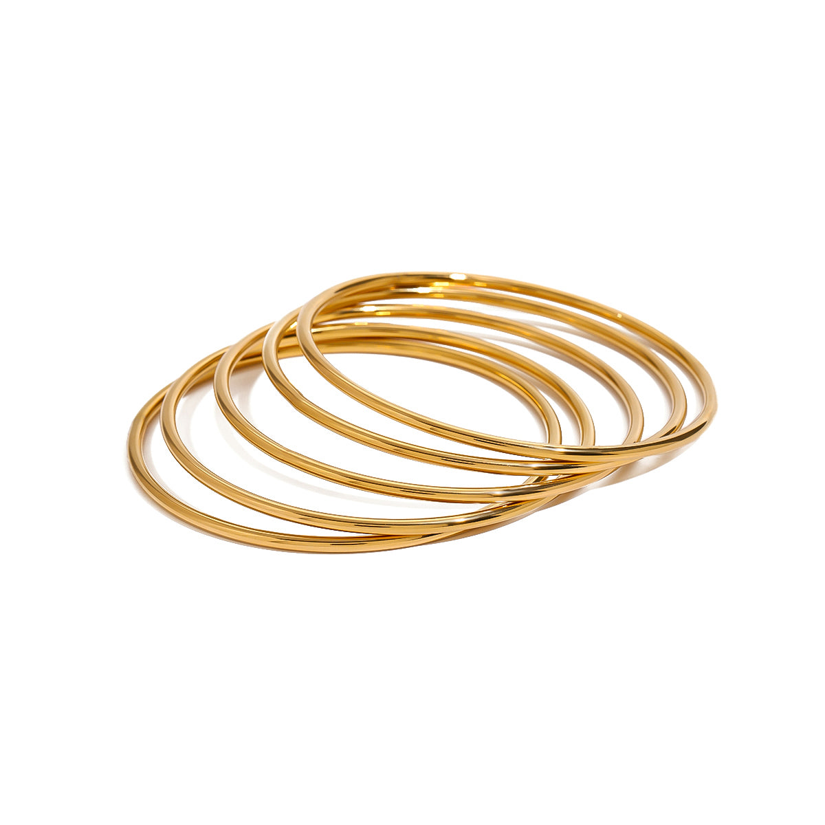Set of gold bangles on a white background
