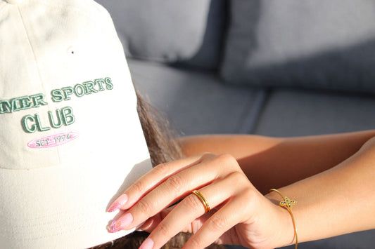 Gold-tone bangle with textured cross and black stones at the center