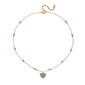 Turquoise pavé heart pendant necklace on delicate gold chain, worn layered with beaded necklaces