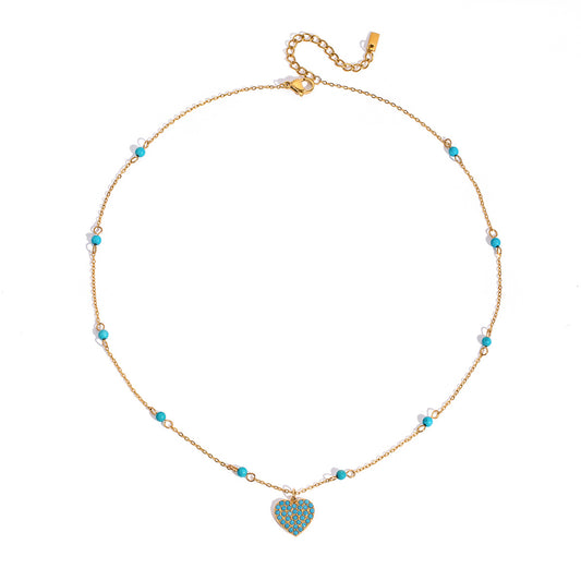 Turquoise pavé heart pendant necklace on delicate gold chain, worn layered with beaded necklaces