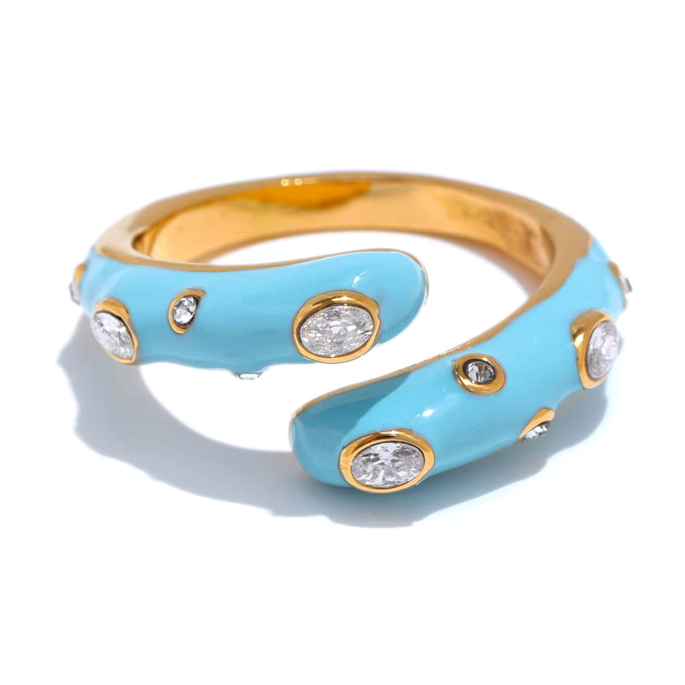 Glossy enamel bypass wrap ring with bezel set oval and round crystals in sky blue and pink on gold band — waterproof hypoallergenic colorful statement ring