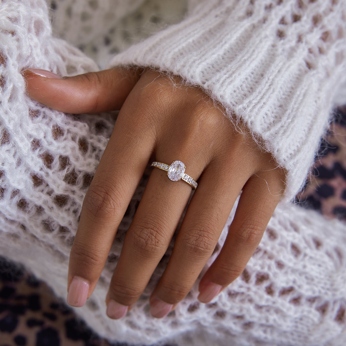 Gold ring with an oval cut clear crystal center stone and pave crystal band