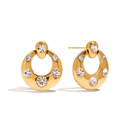 Chunky gold open circle earrings with scattered bezel-set cubic zirconia stones and CZ stud top on white background