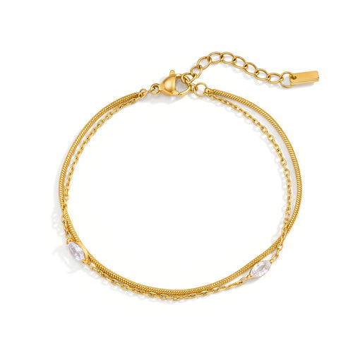 Gold bracelet with chain and pearl-like accents on a white background