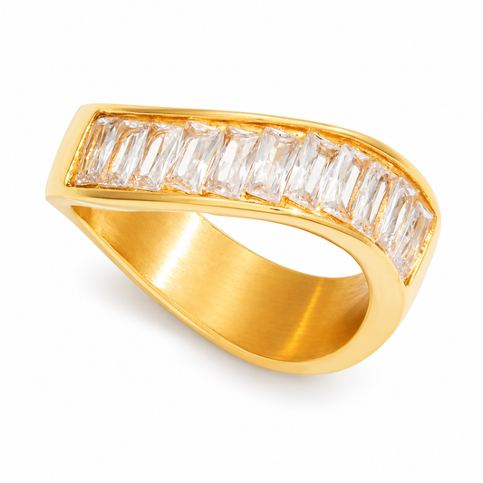 A gold ring with a curved, open-top design featuring a row of clear baguette-cut gemstones on the top surface, shown against a plain white background.