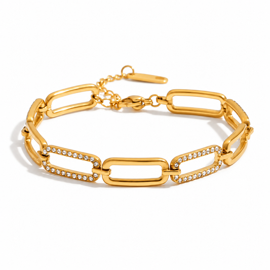 A gold link bracelet with elongated rectangular links, some accented with rows of small clear rhinestones, shown on a clean white background.