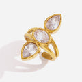 A gold ring featuring three marquise-cut clear gemstones in a leaf-like cluster setting, photographed on a clean white background with a soft shadow.