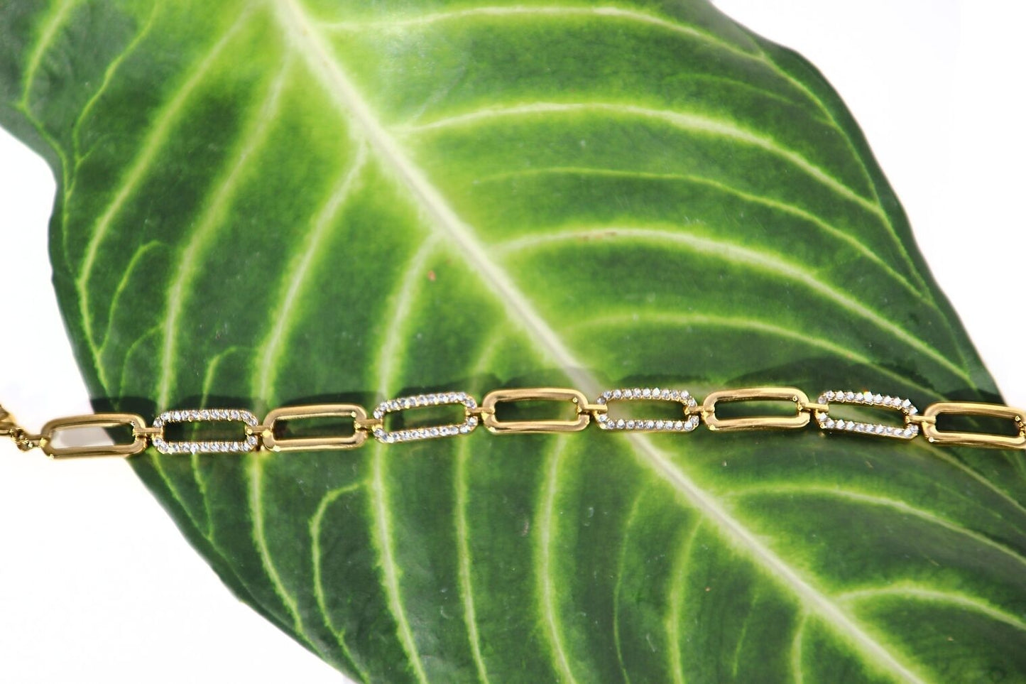 Gold link bracelet with smooth curves and sharp crystal accents