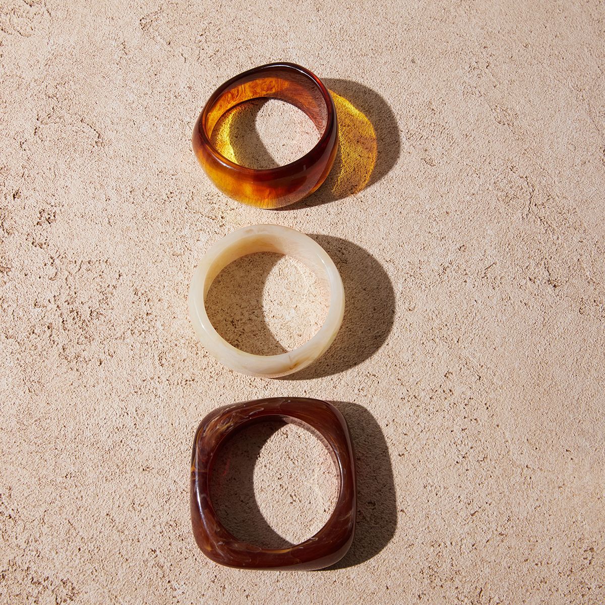 Amayah Jewelry Savanna Resin Bangle Set — three chunky resin bangles in tortoise, white marble, and brown