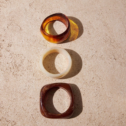 Amayah Jewelry Savanna Resin Bangle Set — three chunky resin bangles in tortoise, white marble, and brown