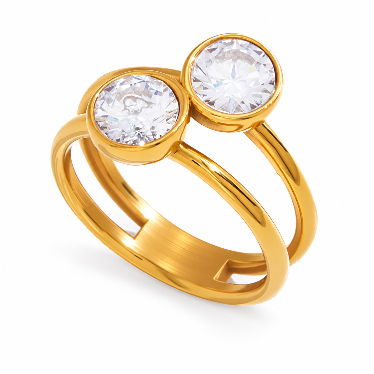 A double gemstone ring in polished yellow gold, featuring two round clear stones in bezel settings on a split band, shown on a white background.