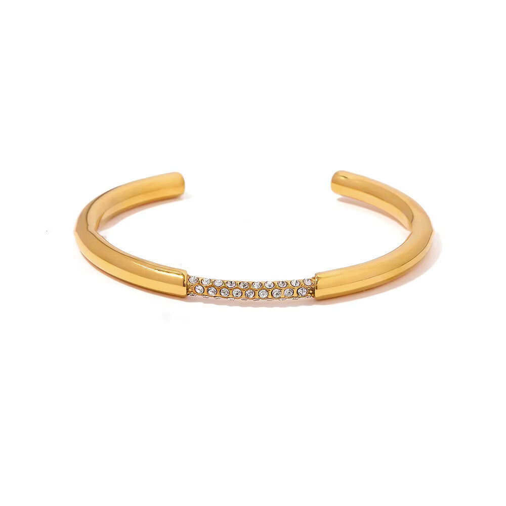 polished gold bangle with a single row of clear, brilliant-cut stones