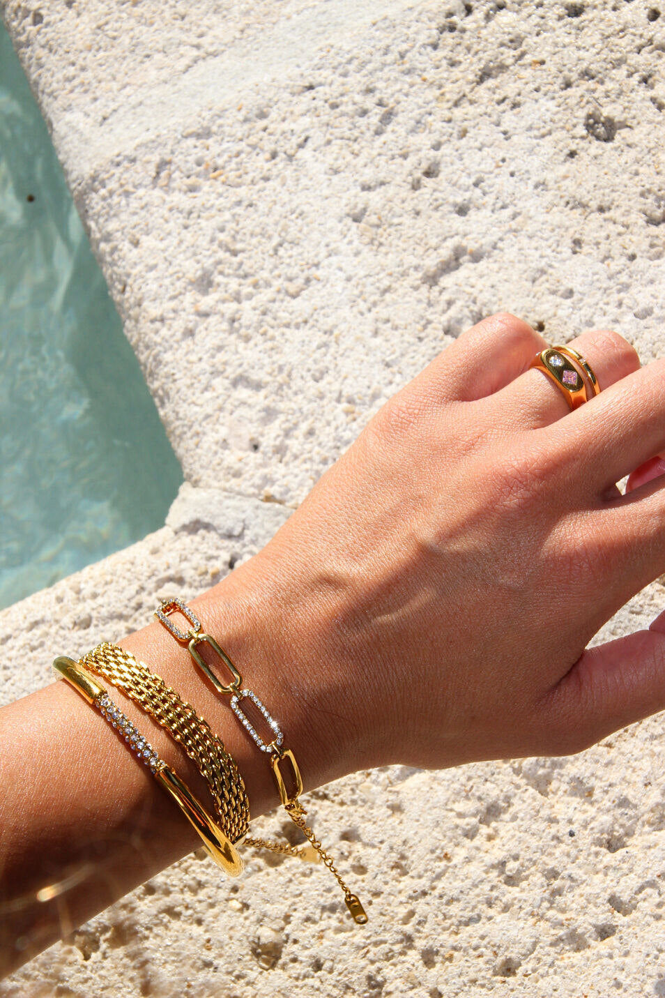 polished gold bangle with a single row of clear, brilliant-cut stones