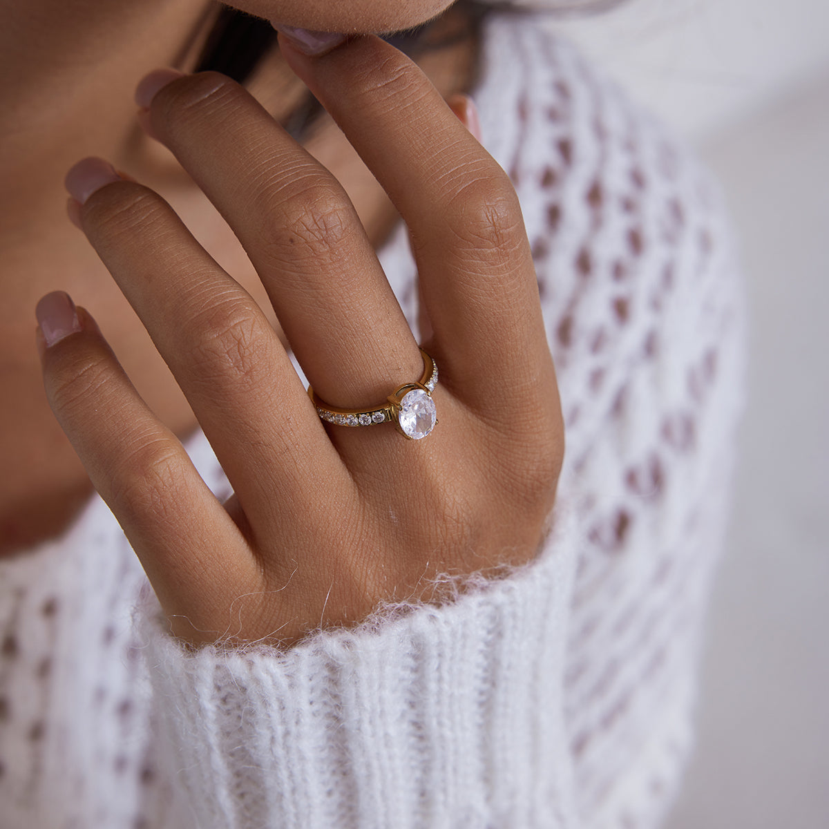 Gold ring with an oval cut clear crystal center stone and pave crystal band