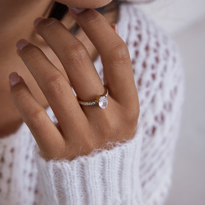 Gold ring with an oval cut clear crystal center stone and pave crystal band