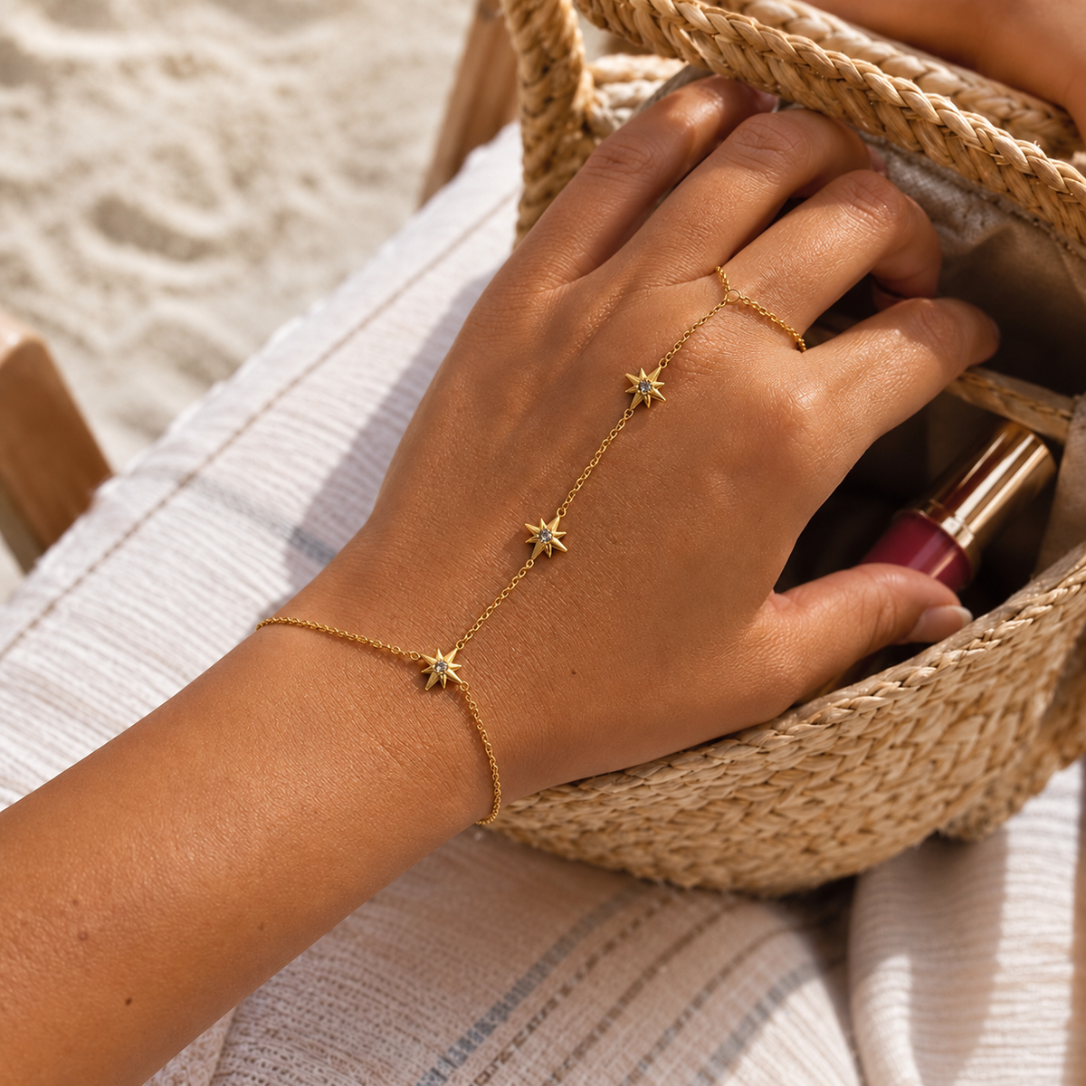 A delicate gold chain anklet featuring three small starburst charms, each adorned with a clear crystal, displayed on a clean white background.