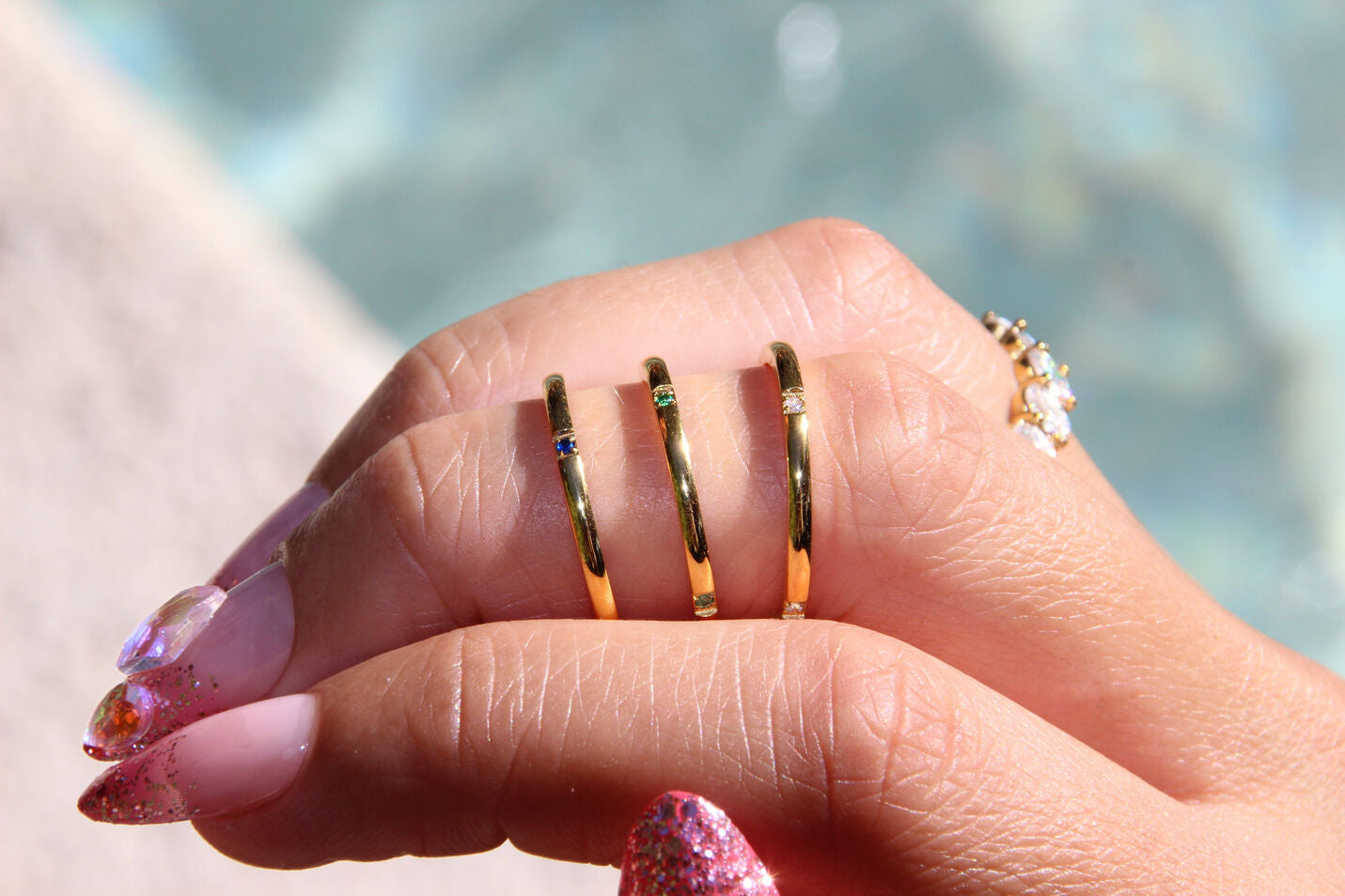 Trio of minimalist gold-plated stainless-steel rings with subtle color and sparkle, perfect for stacking or wearing solo.