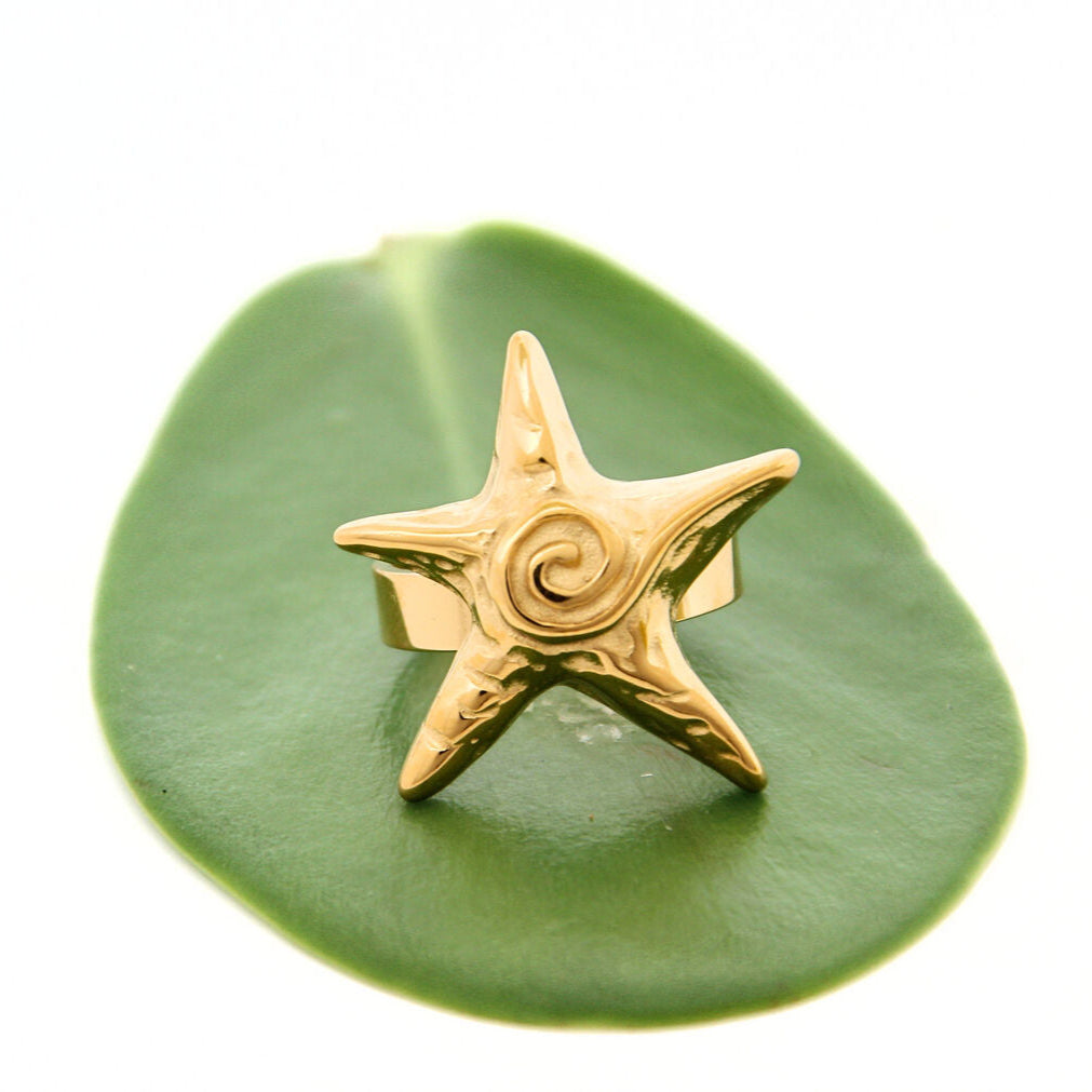 Gold-plated stainless steel starfish ring with swirling details, adjustable fit, perfect for stacking or wearing solo.
