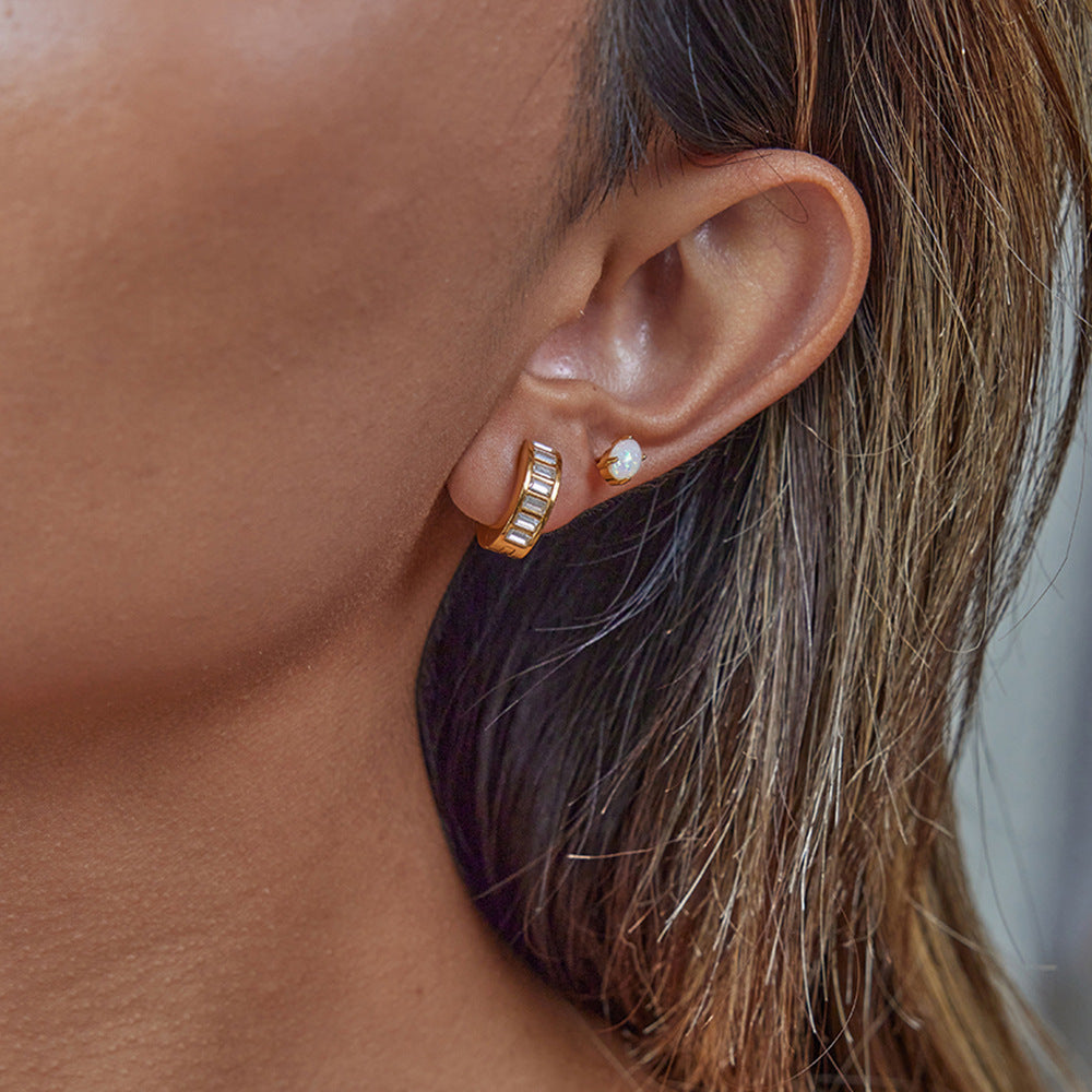 Model wearing Sofia Hoops gold baguette huggie earrings