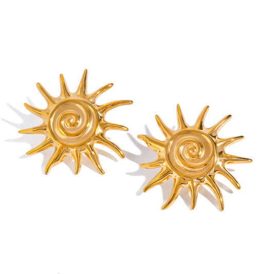 Oversized gold sunburst stud earrings with spiked rays and spiral center on white background