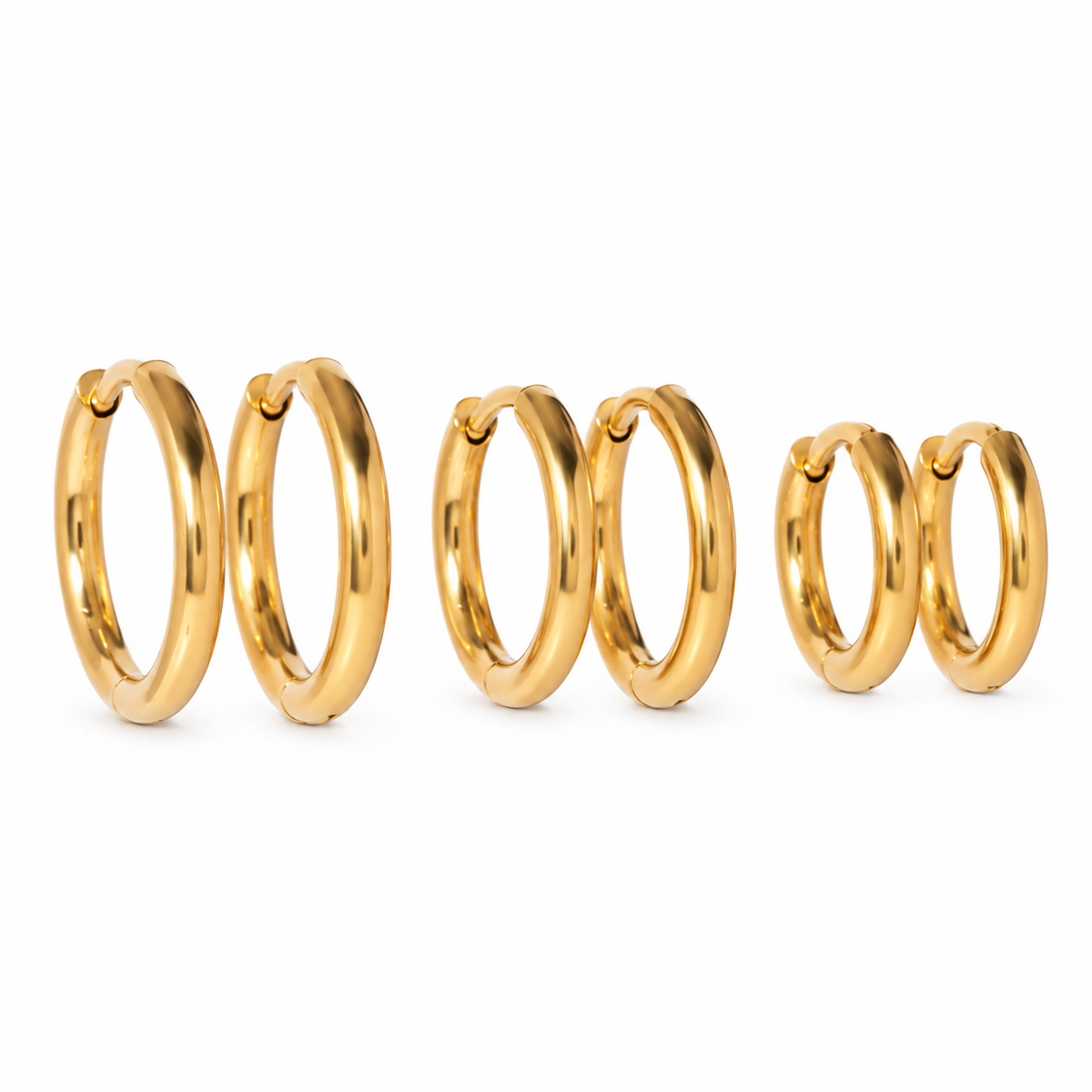 Five pairs of polished gold huggie hoop earrings arranged in descending size order on a clean white background.