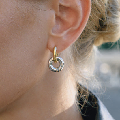 Chunky interlocked double hoop earrings in gold and two-tone gold silver on white background